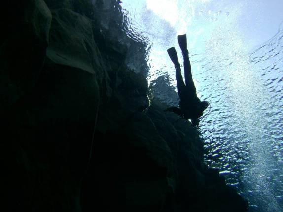 Mergulho nas águas claras e geladas da Silfur Hellir, a fenda que divide a Europa da América, no Parque Nacional Thingvellir, na Islândia